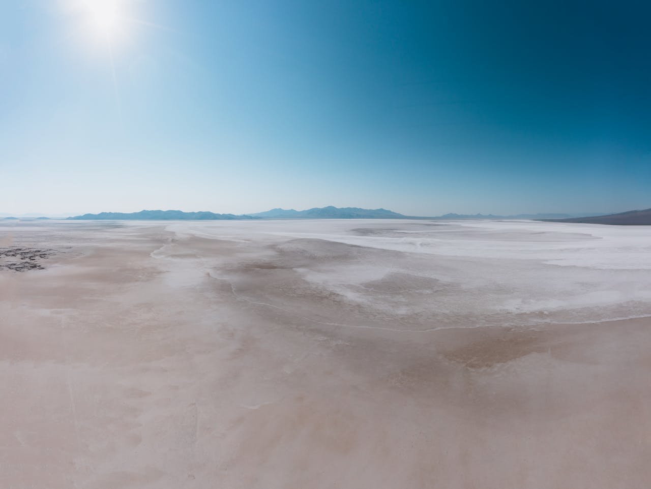 A wide desert scene under a clear blue sky, showcasing the vastness and tranquility of nature.